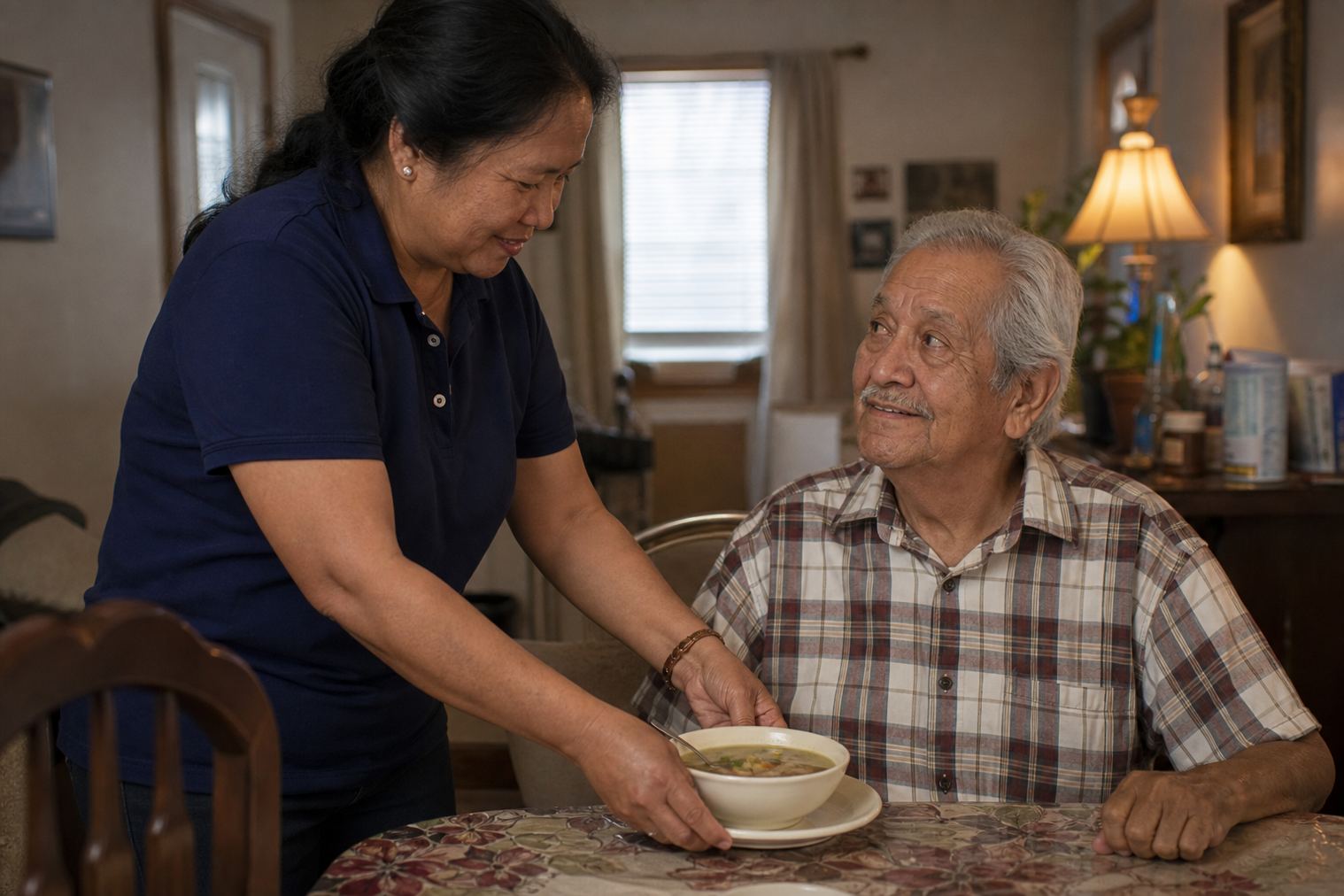A caregiver serving a meal to an older adult at home in Joliet