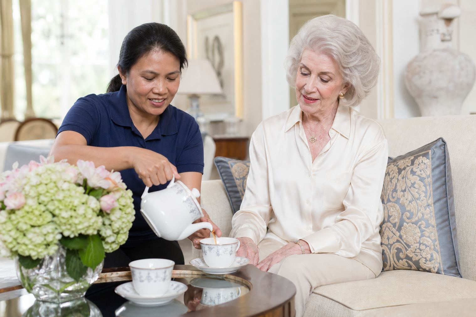 A caregiver pouring tea for an older adult at home in Oak Brook